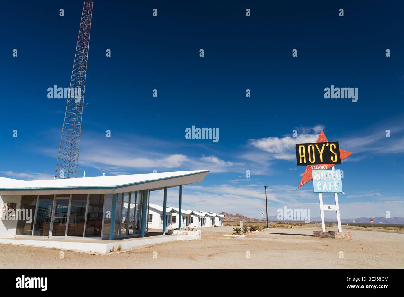 Das historische Gebäude im Mid-Century-Modern-Stil und das ikonische Straßenschild von Roy's Motel und Café unter einem tiefblauen Himmel an der Route 66 in Amboy, Kalifornien. Stockfoto