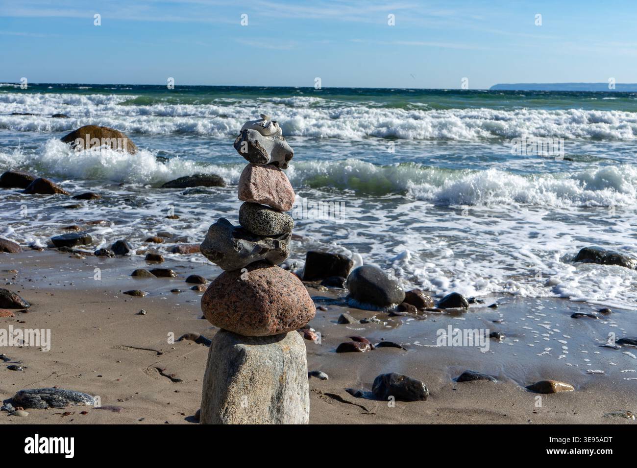 Balancierung von Steinen an einem Kiesstrand an der Ostsee Stockfoto
