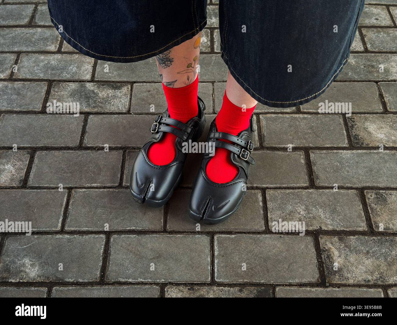 Tabi-Schuhe mit roten Socken und Bermudas - Smartphone-aufgenommenes Stockfoto