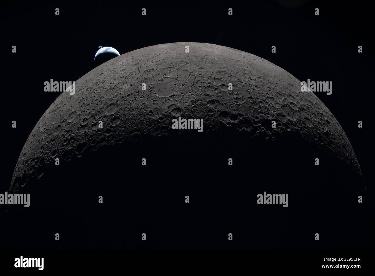 Auf diesem Foto, das von der Artemis II-Crew während ihrer Reise um die andere Seite des Mondes aufgenommen wurde, liegt die Erde über dem geschwungenen Bein des Mondes Stockfoto