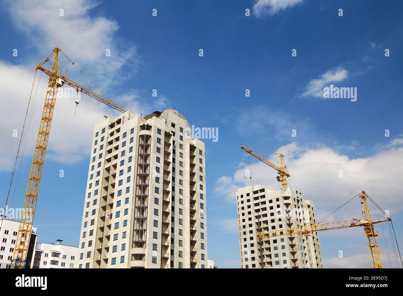 Unteransicht der Hochhäuser, die mit Baukränen gebaut werden Stockfoto