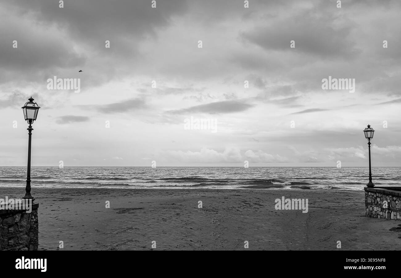 Bezaubernder Abschnitt des Alassio Strandes mit Straßenlaternen bis zum Ufer Stockfoto