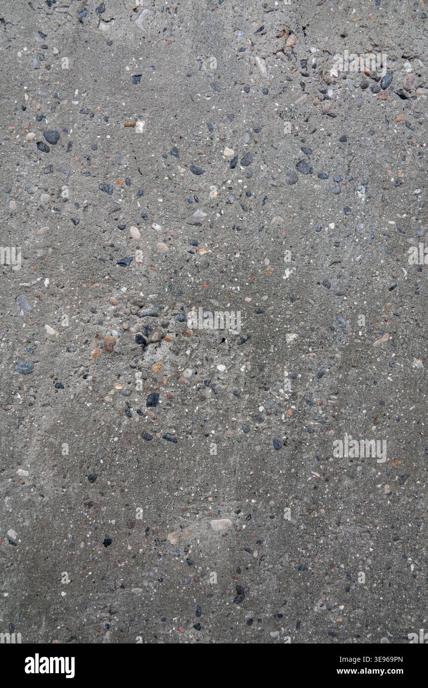 Textur rauer Betonwände mit sichtbaren Steinen. Nahaufnahme der grauen Betonwand für Vorlage und Hintergrund. Stockfoto