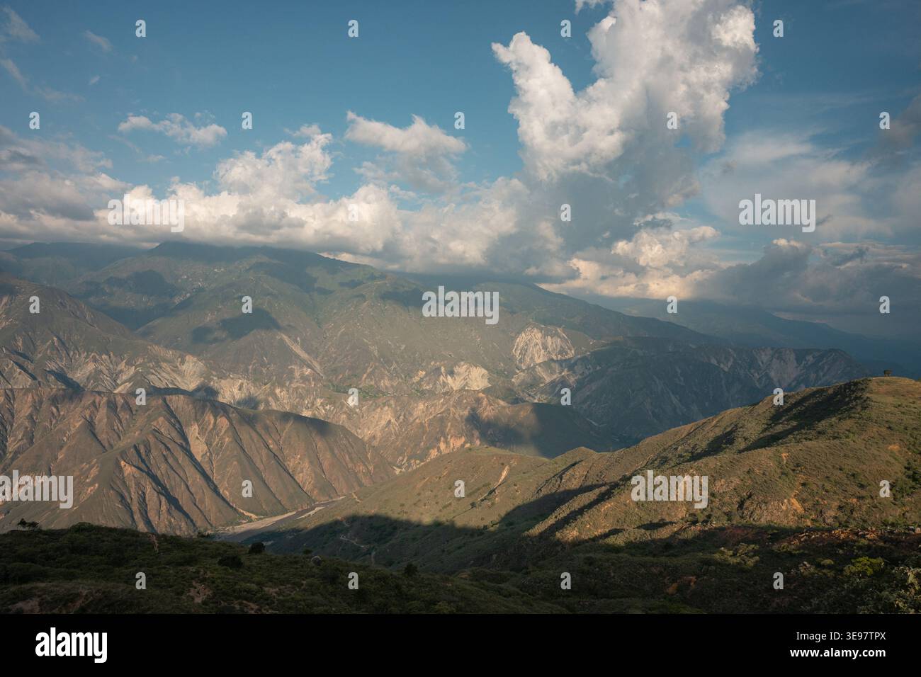 Weitläufiges Panorama des chicamocha Canyons in kolumbien, schroffe Berge und tiefe Täler unter einem teilweise bewölkten blauen Himmel, Sonnenlicht und Schatten bilden sich Stockfoto