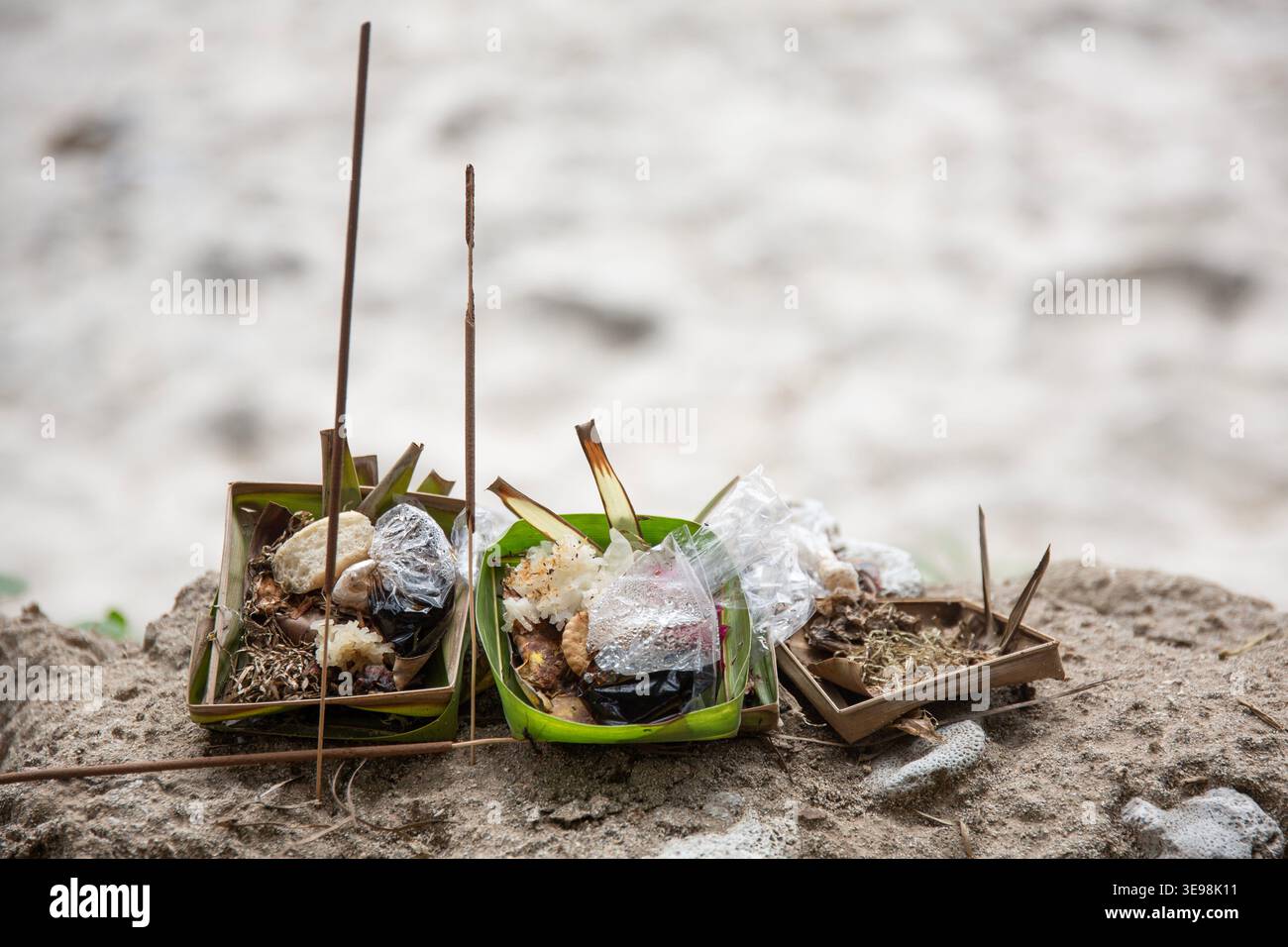 Traditionelle balinesische Canang-Sari-Angebote auf Sand am Strand in Bali, Indonesien Stockfoto