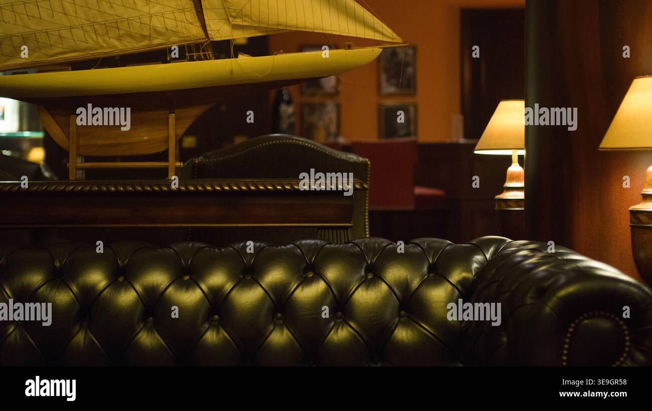 Elegantes klassisches Interieur mit Chesterfield-Ledersofa und Segelboot in Luxemburg-Stadt. Stockfoto