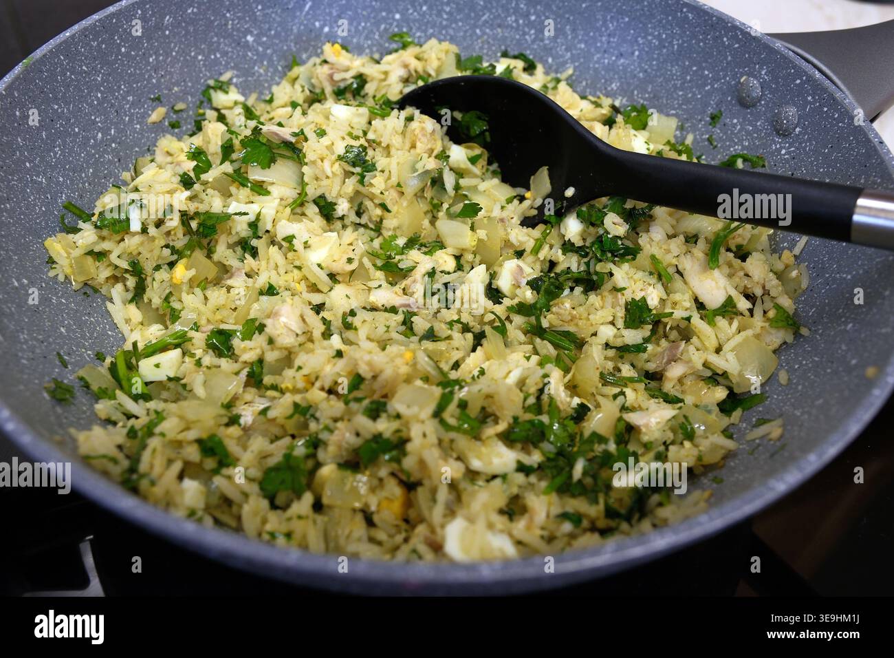Hausgemachte Kedgeree in einer Antihaftpfanne, geräucherter Schellfisch mit flauschigem Reis, frischer Petersilie und gekochten Eiern, traditionelle anglo-indische Küche Stockfoto