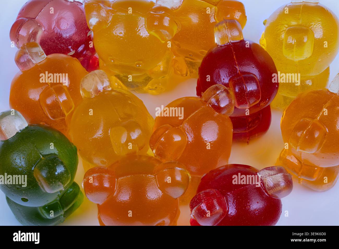 Symmetrisches Gitterlayout mit Gummibären für die Produktpräsentation, heller Studiohintergrund, einheitliche Reihen heben die Farbvariante hervor und sind für den Einzelhandel geeignet Stockfoto
