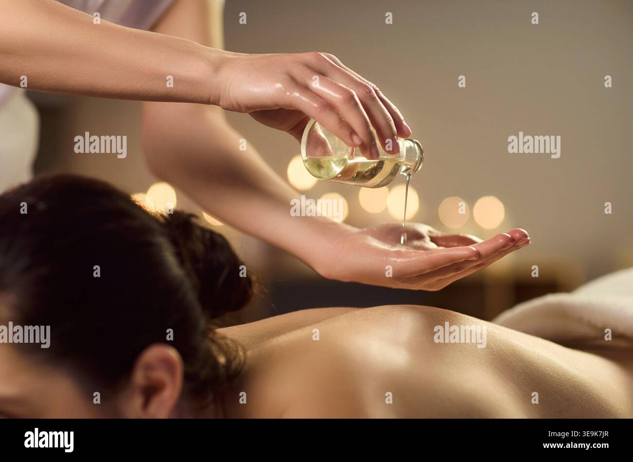 Aromatherapie-Massage mit Öl auf den Rücken im Spa, warmen Kerzen und entspannender Pflege Stockfoto