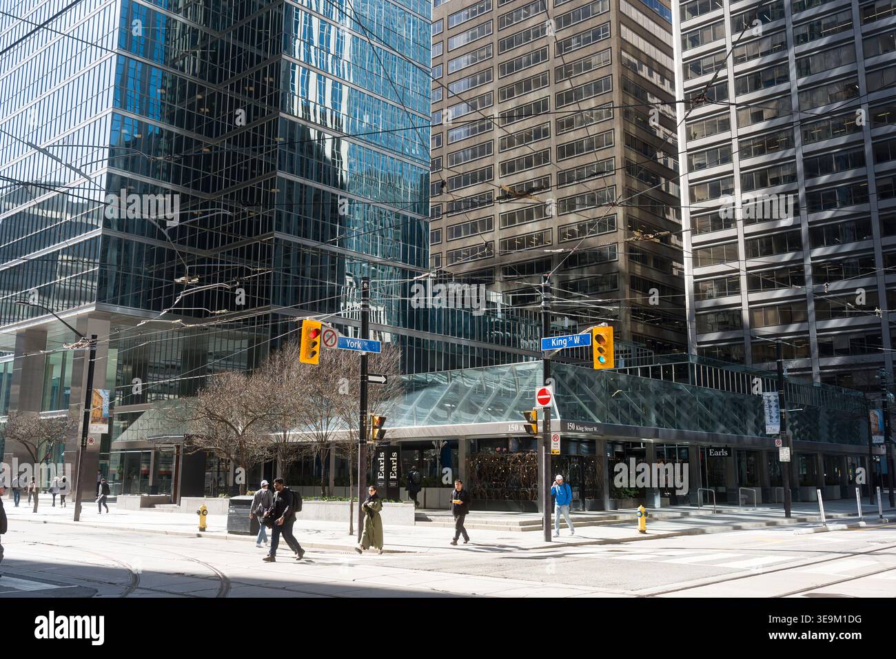 Toronto, Kanada - 17. April 2026: Die pulsierende Straßenkreuzung der Stadt strotzt nur so vor Fußgängern, die zwischen glitzernden Wolkenkratzern spazieren Stockfoto