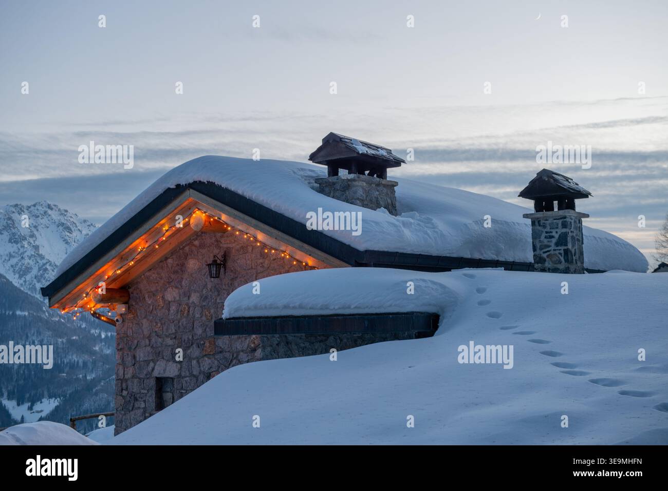 Bauernhaus im Schnee bei Sonnenuntergang Stockfoto