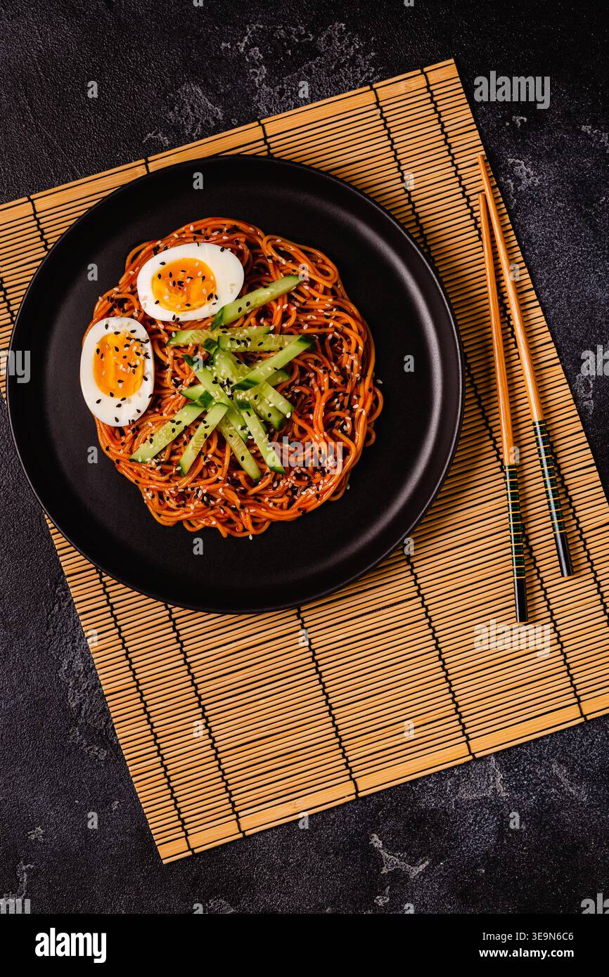 Traditionelles koreanisches Essen, Gurke und gekochte Eier, kalte, scharfe Nudeln, Blick von oben. Stockfoto