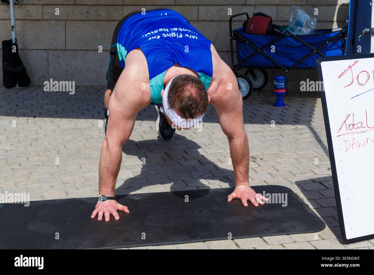 Bournemouth, Dorset, Großbritannien. April 2026. Russell Tickner strebt 2.000 Burpees an, um Geld für die psychische Gesundheit Wohltätigkeitsorganisation Dorset Mind zu sammeln und ermutigt Mitglieder der Öffentlichkeit, mitzumachen. Bei der Veranstaltung spricht Russell mit der Öffentlichkeit über psychische Gesundheit, wird niedergeschlagen, aber wie ein Burpee, das wieder aufsteht und mit der richtigen Unterstützung stärker steigt - ob er sein Ziel erreicht oder nicht, es zeigt, dass er offen und verletzlich ist, so dass die Menschen den Kampf und Hilfe sehen können, denn das ist Leben, es ist nicht Perfektion, sondern Bewusstsein, zeigt Unterstützung & Zweisamkeit. Quelle: Carolyn Jenkins/Alamy Live News Stockfoto