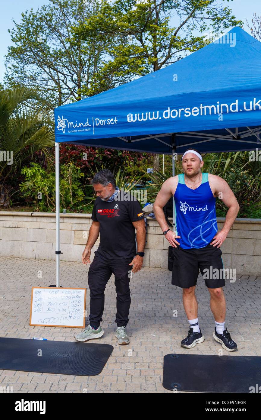 Bournemouth, Dorset, Großbritannien. April 2026. Russell Tickner strebt 2.000 Burpees an, um Geld für die psychische Gesundheit Wohltätigkeitsorganisation Dorset Mind zu sammeln und ermutigt Mitglieder der Öffentlichkeit, mitzumachen. Bei der Veranstaltung spricht Russell mit der Öffentlichkeit über psychische Gesundheit, wird niedergeschlagen, aber wie ein Burpee, das wieder aufsteht und mit der richtigen Unterstützung stärker steigt - ob er sein Ziel erreicht oder nicht, es zeigt, dass er offen und verletzlich ist, so dass die Menschen den Kampf und Hilfe sehen können, denn das ist Leben, es ist nicht Perfektion, sondern Bewusstsein, zeigt Unterstützung & Zweisamkeit. Quelle: Carolyn Jenkins/Alamy Live News Stockfoto