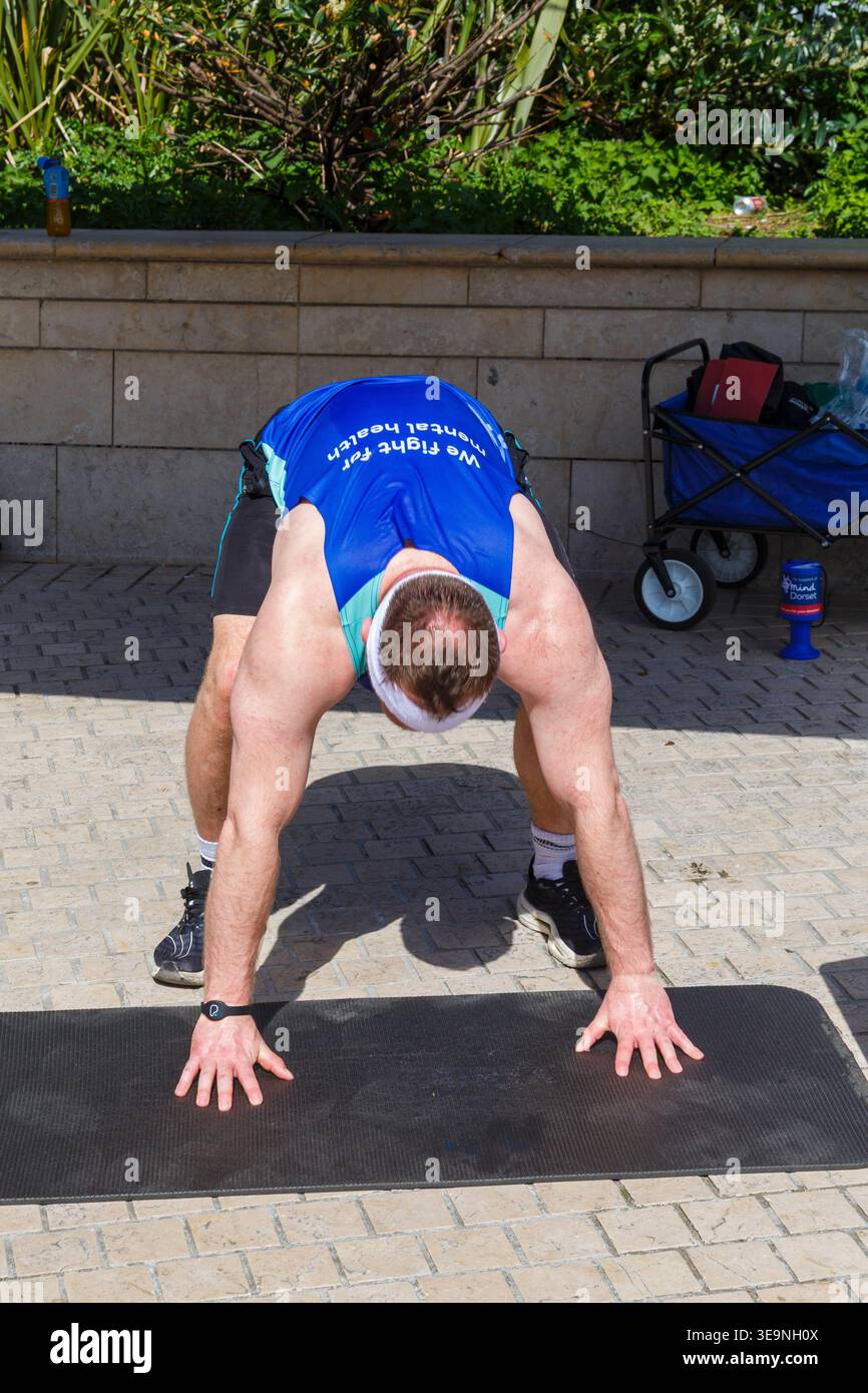Bournemouth, Dorset, Großbritannien. April 2026. Russell Tickner strebt 2.000 Burpees an, um Geld für die psychische Gesundheit Wohltätigkeitsorganisation Dorset Mind zu sammeln und ermutigt Mitglieder der Öffentlichkeit, mitzumachen. Bei der Veranstaltung spricht Russell mit der Öffentlichkeit über psychische Gesundheit, wird niedergeschlagen, aber wie ein Burpee, das wieder aufsteht und mit der richtigen Unterstützung stärker steigt - ob er sein Ziel erreicht oder nicht, es zeigt, dass er offen und verletzlich ist, so dass die Menschen den Kampf und Hilfe sehen können, denn das ist Leben, es ist nicht Perfektion, sondern Bewusstsein, zeigt Unterstützung & Zweisamkeit. Quelle: Carolyn Jenkins/Alamy Live News Stockfoto