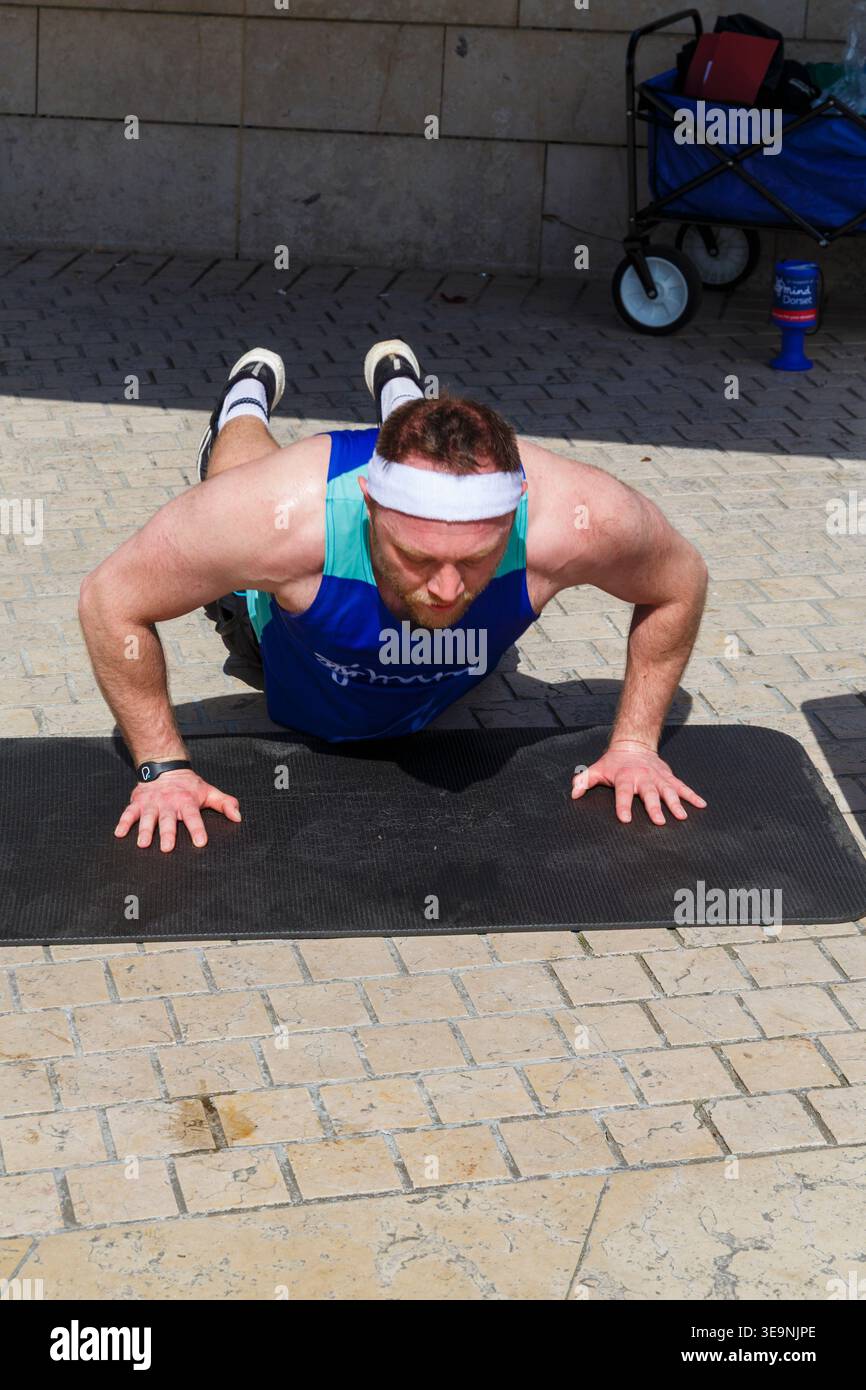 Bournemouth, Dorset, Großbritannien. April 2026. Russell Tickner strebt 2.000 Burpees an, um Geld für die psychische Gesundheit Wohltätigkeitsorganisation Dorset Mind zu sammeln und ermutigt Mitglieder der Öffentlichkeit, mitzumachen. Bei der Veranstaltung spricht Russell mit der Öffentlichkeit über psychische Gesundheit, wird niedergeschlagen, aber wie ein Burpee, das wieder aufsteht und mit der richtigen Unterstützung stärker steigt - ob er sein Ziel erreicht oder nicht, es zeigt, dass er offen und verletzlich ist, so dass die Menschen den Kampf und Hilfe sehen können, denn das ist Leben, es ist nicht Perfektion, sondern Bewusstsein, zeigt Unterstützung & Zweisamkeit. Quelle: Carolyn Jenkins/Alamy Live News Stockfoto