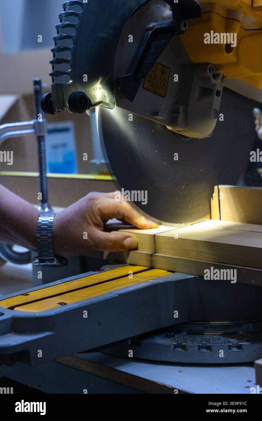 Schneiden von Holz mit Gehrungssäge in der Werkstatt Nahaufnahme Stockfoto