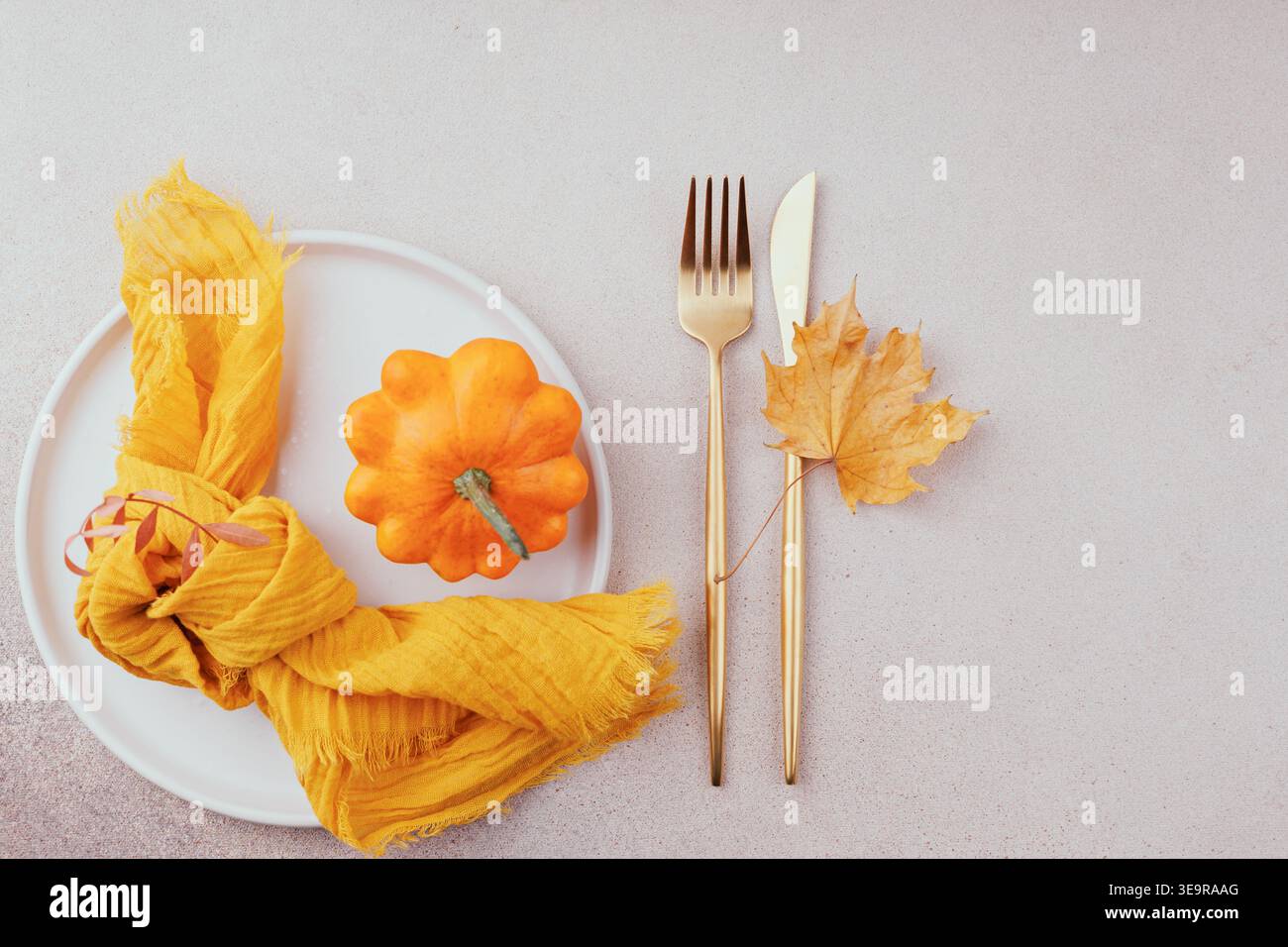 Einrichtung im Herbst mit gelber Serviette und trockenem Blatt Stockfoto