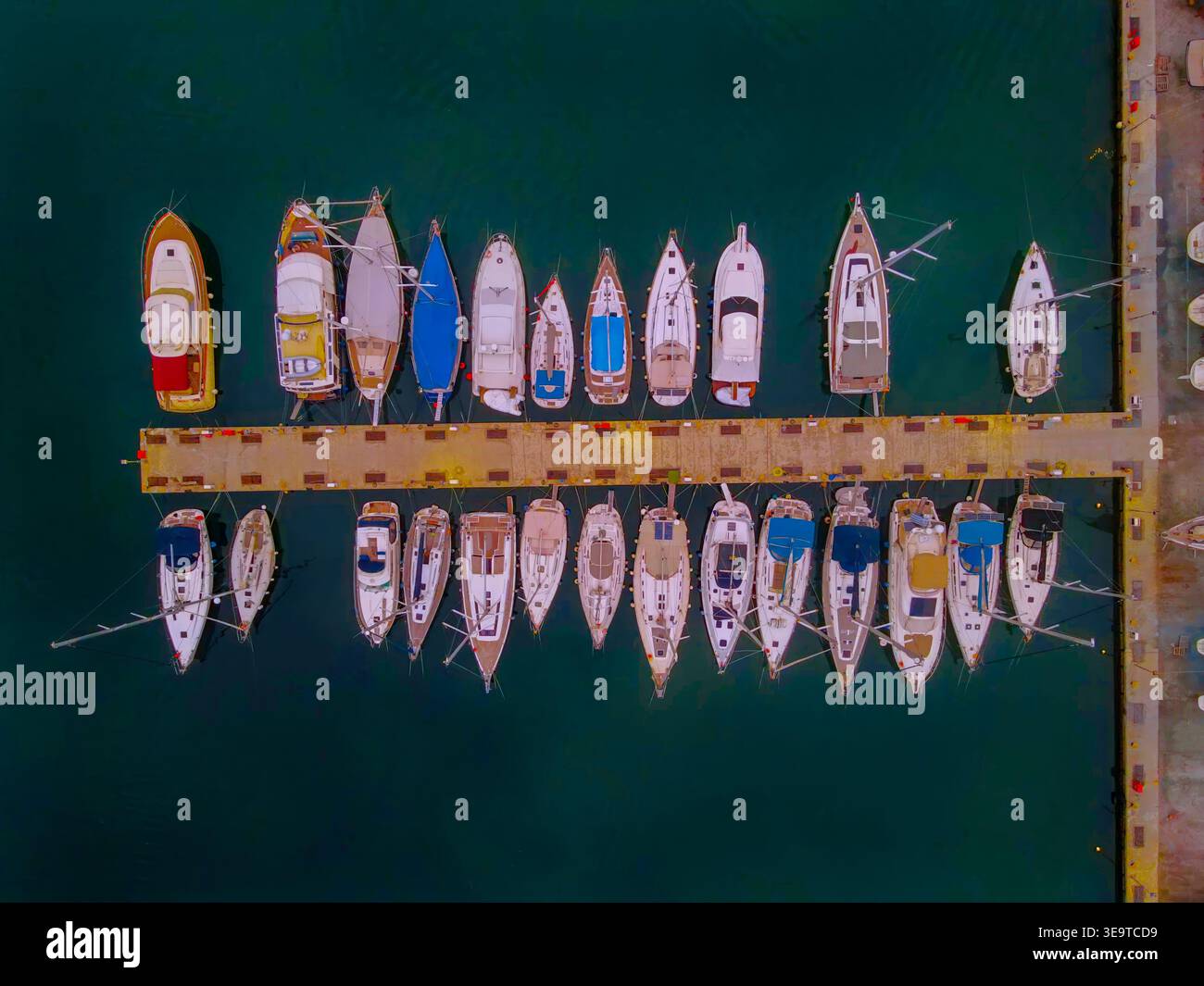 Von oben aus der Drohne aus der Vogelperspektive auf Segelboote und Motorboote, die an einem Yachthafen-Pier in Griechenland vor Anker liegen Stockfoto