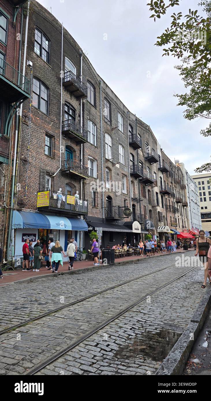 Historische River Street mit Kopfsteinpflasterstraße und alten Backsteinhäusern entlang der Savannah Waterfront, Georgia, USA. Beliebte Touristengegend mit Geschäften, Café - Smartphone-aufgenommenes Stockfoto