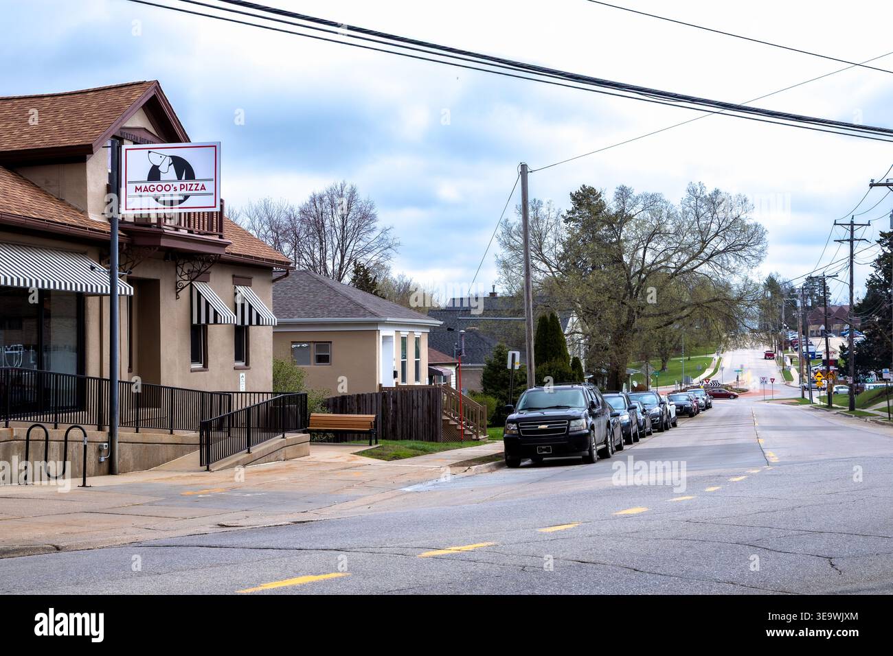 Dubuque, Iowa, USA - 13. April 2026: Magoo's Pizza auf der University Avenue mit einer Reihe geparkter Autos Stockfoto
