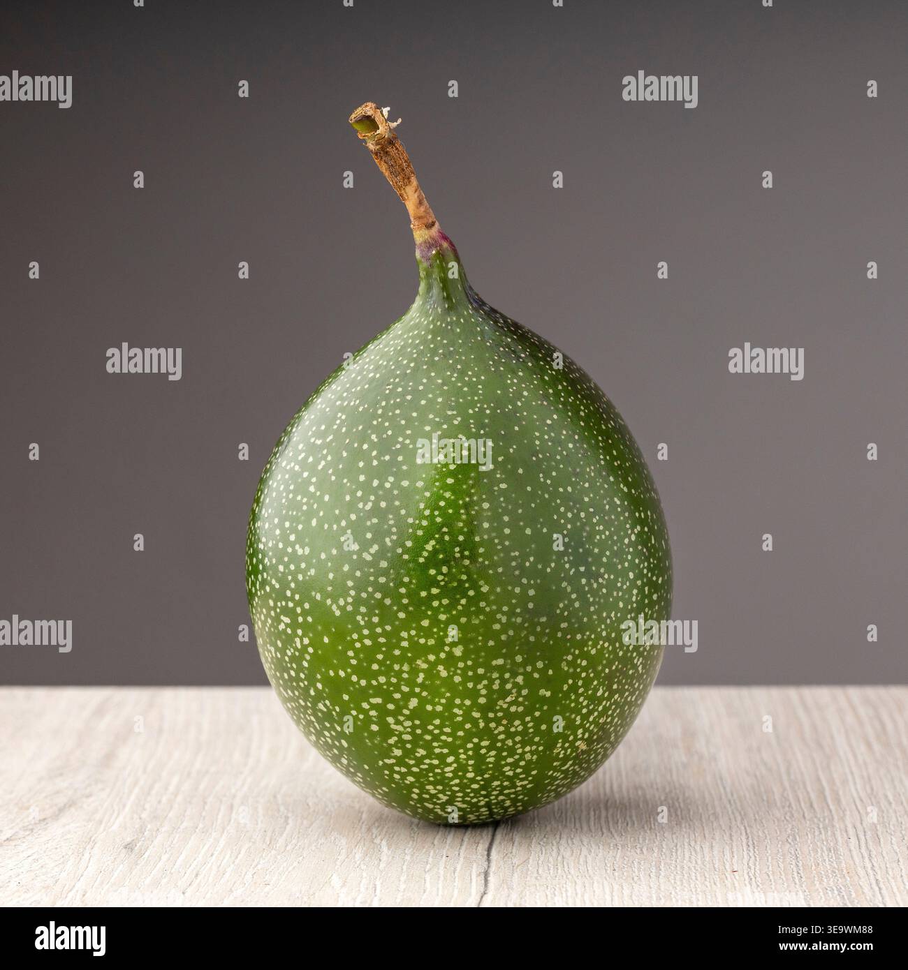 Unreife grüne Passionsfrucht auf einem Holztisch - Passiflora ligularis Stockfoto