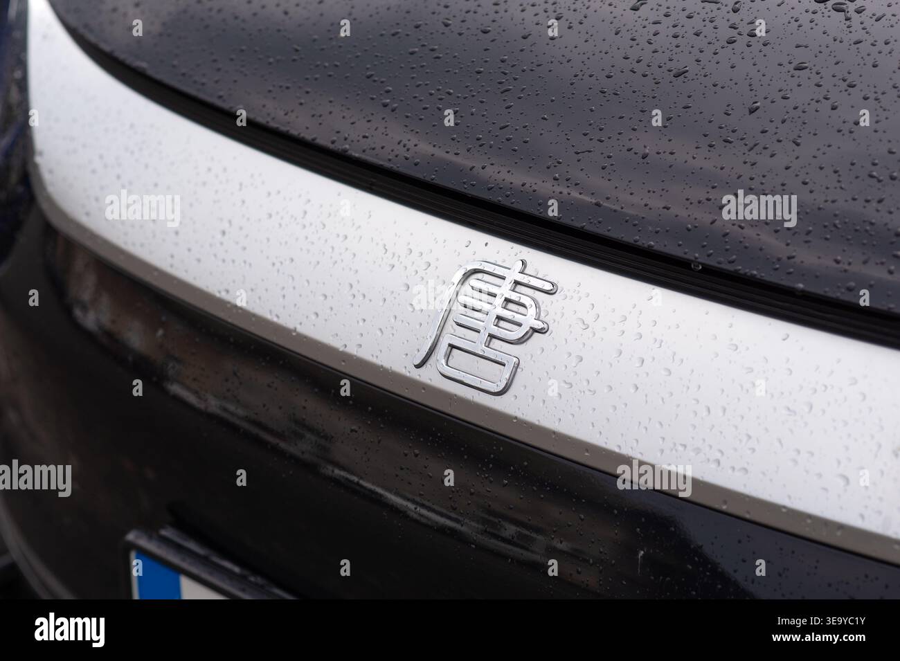 Kiew, Ukraine - 22. August 2025: BYD Tang SUV, moderne elektrische Frequenzweiche, im Freien geparkt. Nahaufnahme des chinesischen Autologos mit Regentropfen auf der Fahrzeugoberfläche Stockfoto