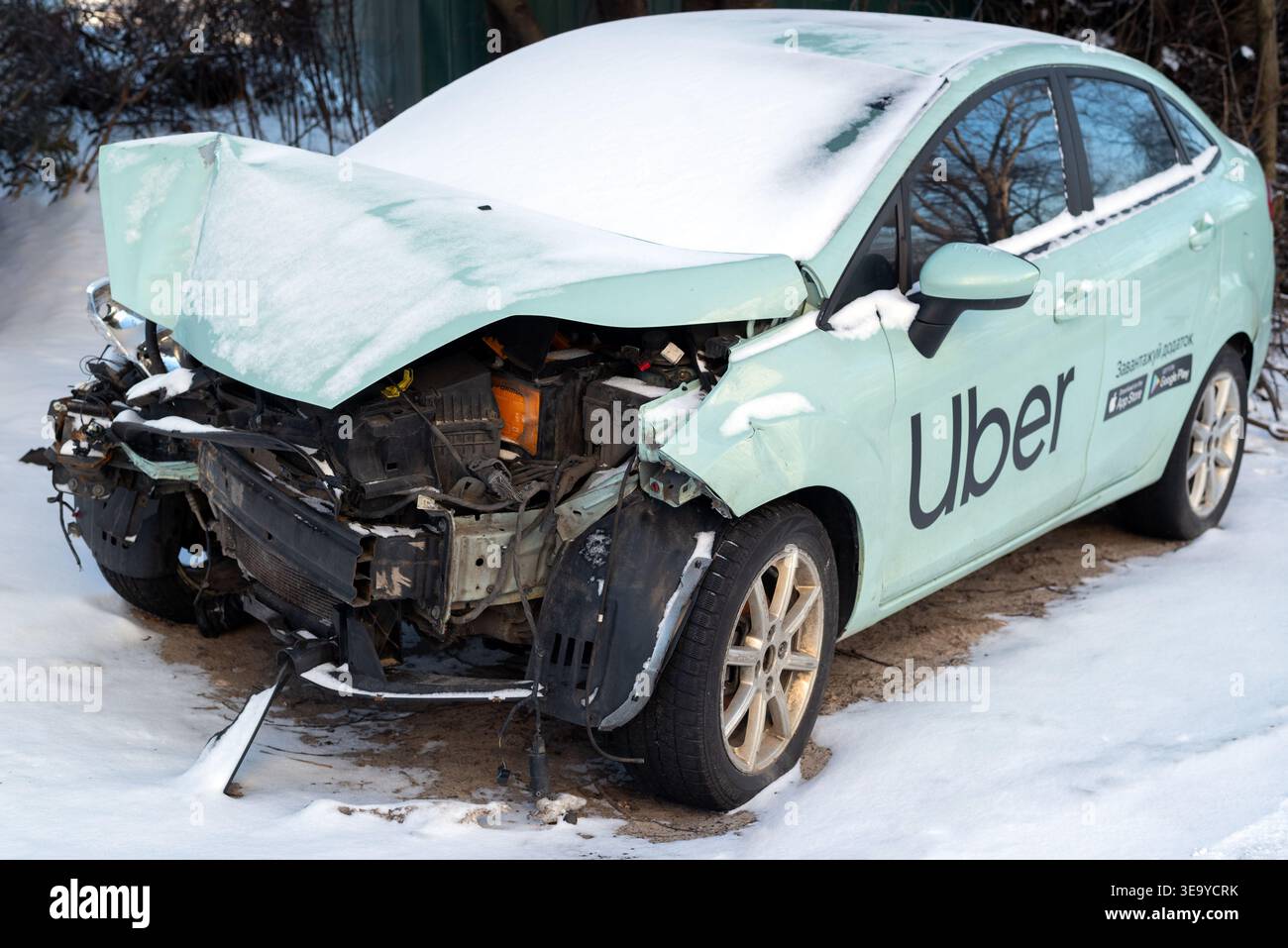 Kiew, Ukraine. Januar 2024. Das Auto des Uber-Taxis wurde nach einem Zusammenstoß auf einem Parkplatz zerstört. Kaputtes Auto nach einem Unfall im Winter Stockfoto