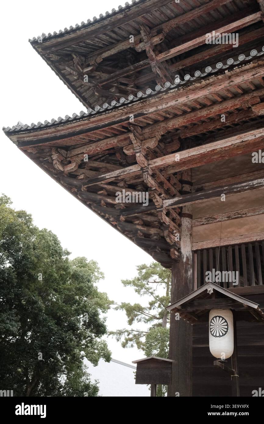 Altes japanisches Tempeldach mit kunstvoller Holzkonstruktion und traditioneller Laterne Stockfoto