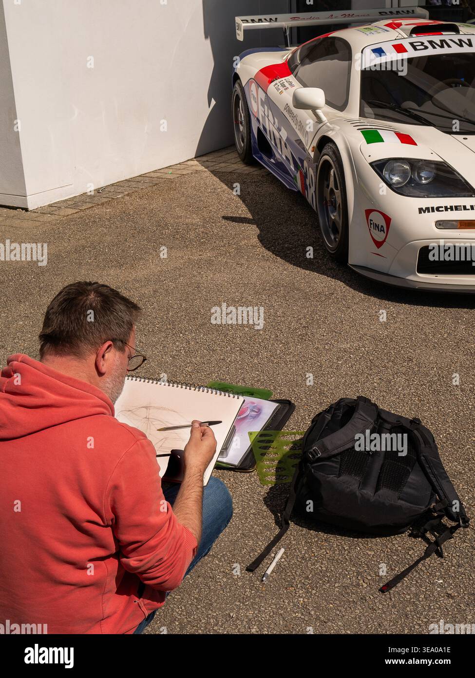April 2026: Ein Künstler zeichnet einen Maclaren im Fahrerlager auf der Goodwood-Rennstrecke während des Mitgliedertreffens 83, 2026 Stockfoto