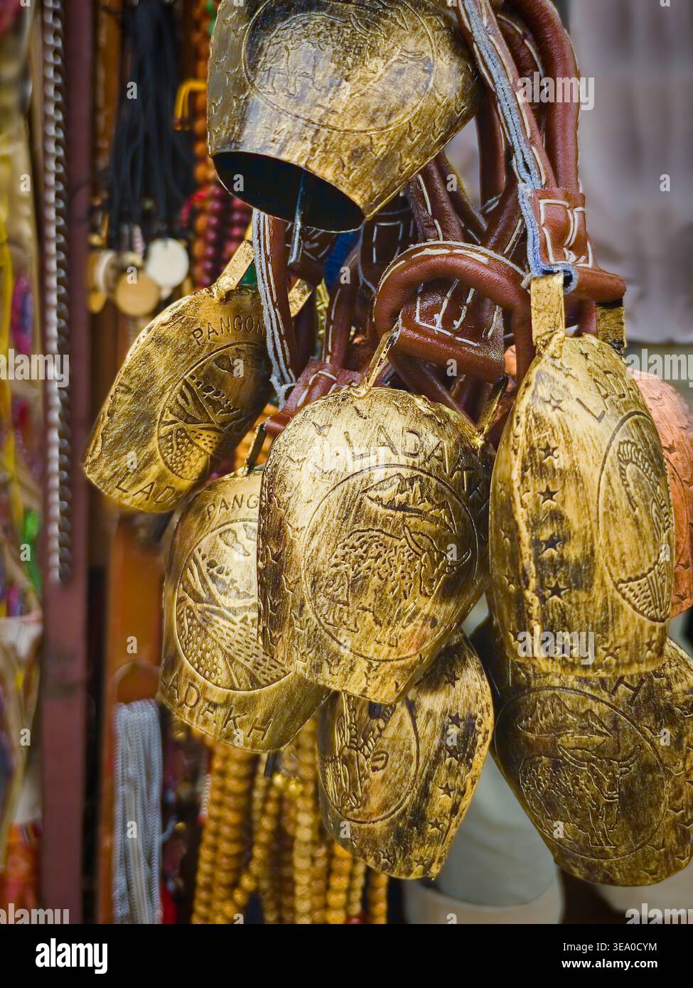 Nahaufnahme handgefertigter Messingglocken mit eingravierten Ladakh-Motiven auf dem lokalen Markt in Leh, Himalaya Indien, authentische kulturelle und spirituelle Souvenirs Stockfoto