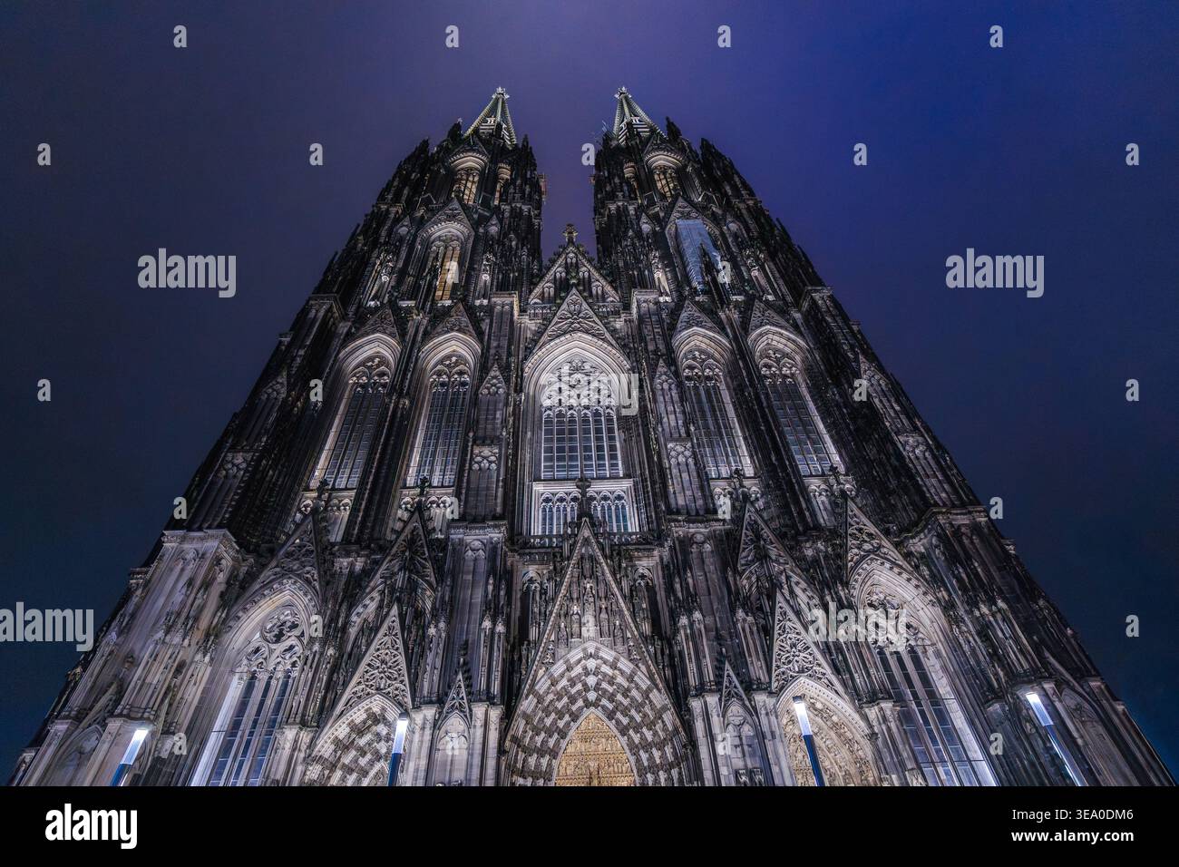 Beleuchtete Kölner Domfassade bei Nacht mit dramatischen gotischen Türmen Stockfoto