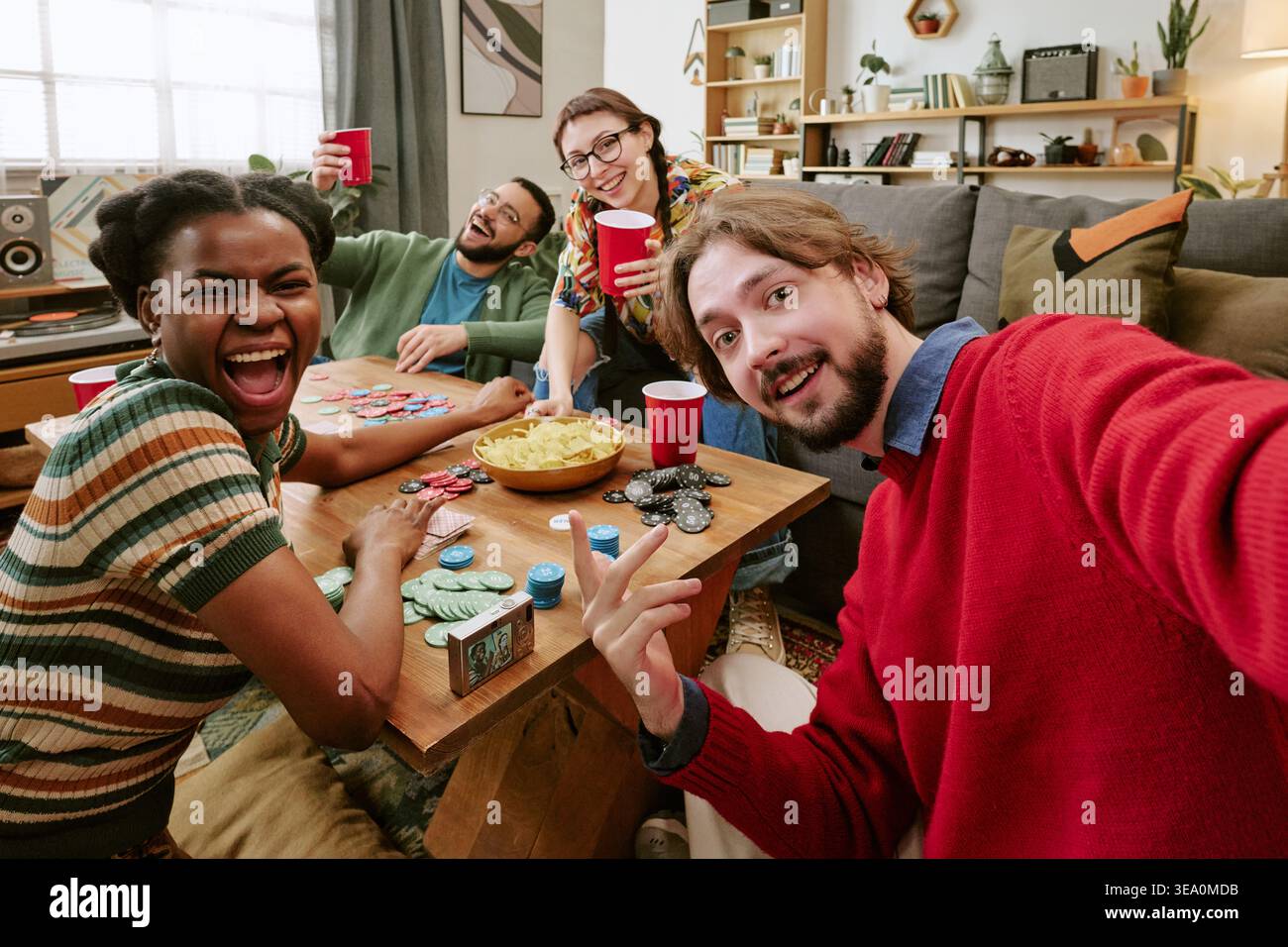 Porträt verschiedener Freunde, die während der House Party Poker spielen Stockfoto