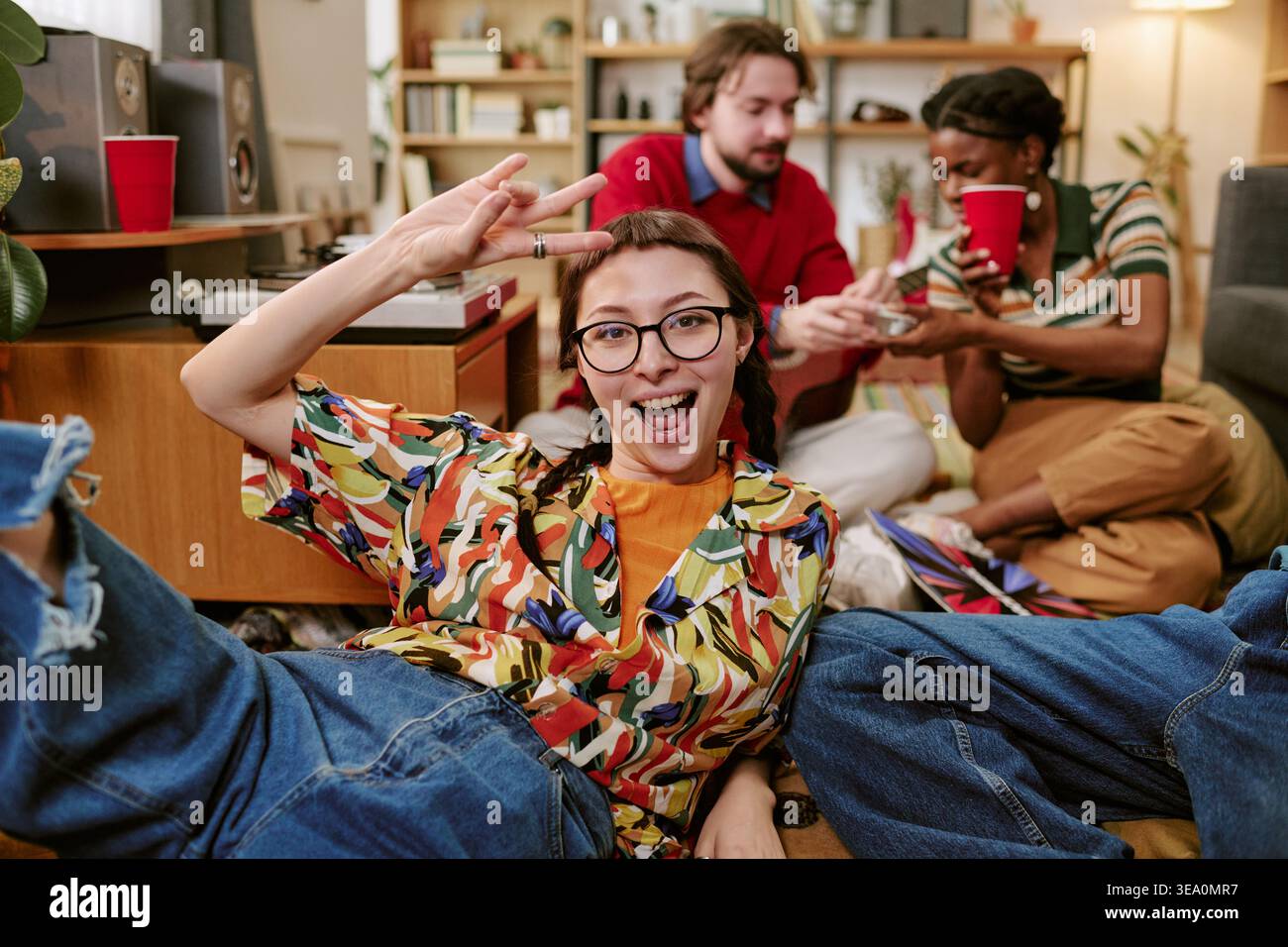 Porträt einer jungen Frau, die sich mit Freunden zu Hause entspannt Stockfoto