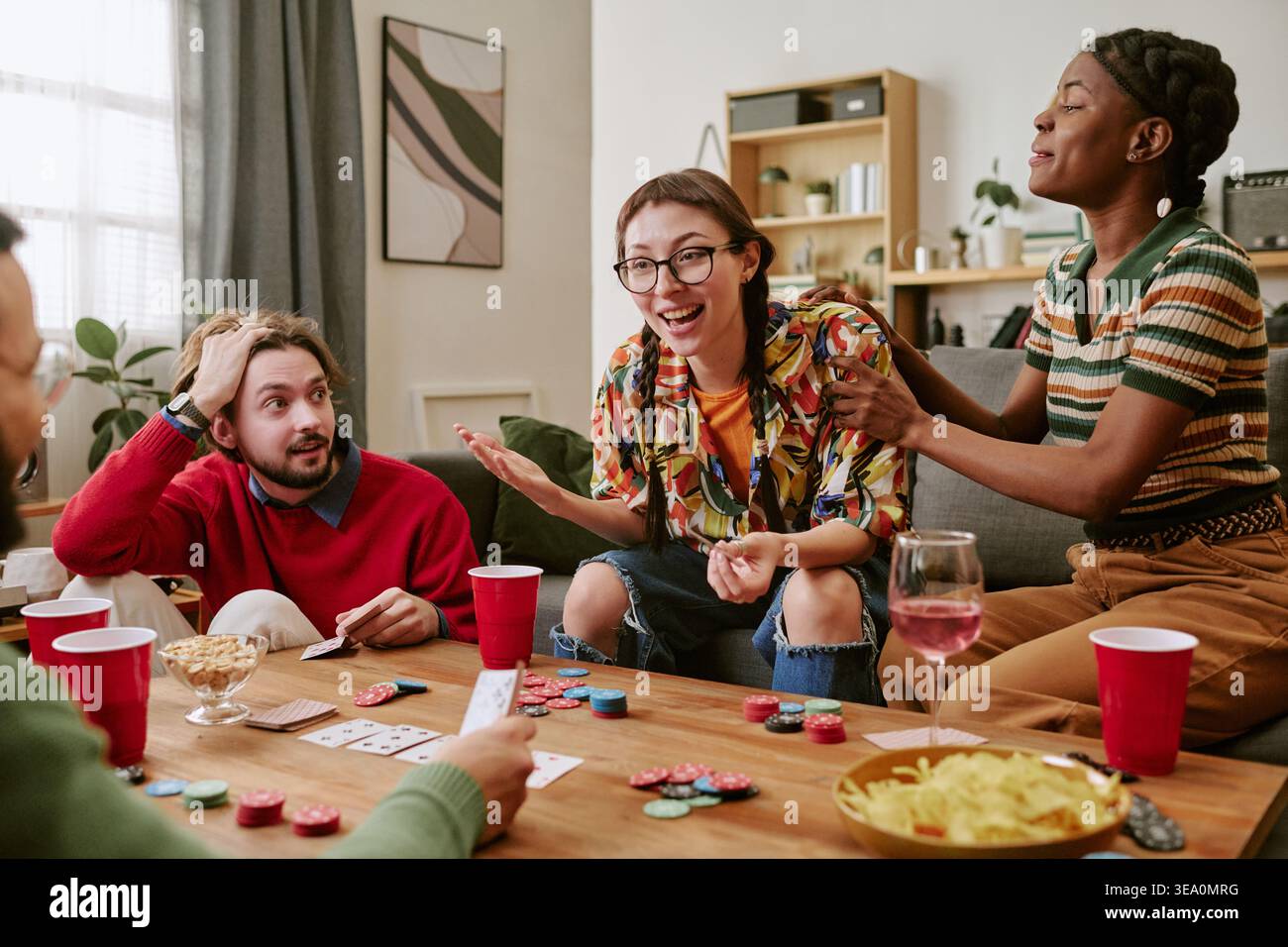 Verschiedene Freunde spielen Poker während der lockeren Home Social Meeting Stockfoto