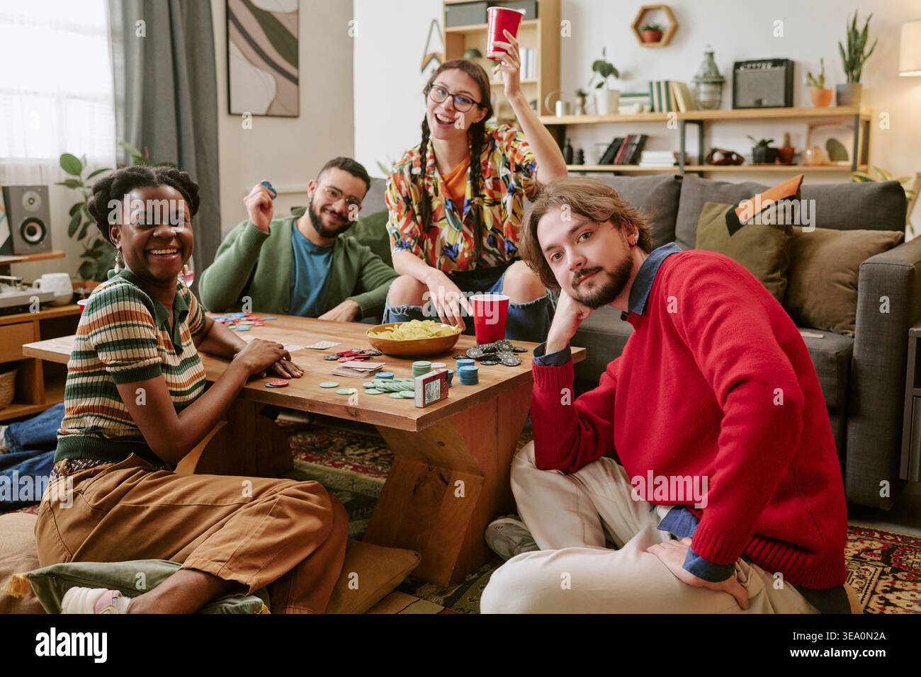 Porträt verschiedener Freunde, die während der Heimparty Poker spielen Stockfoto