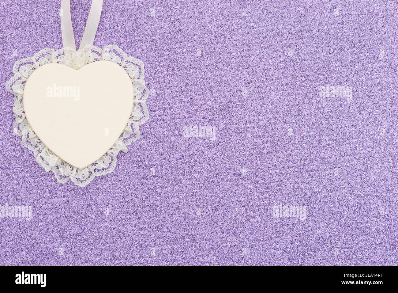 Weißes Spitzen-Herz-Ornament auf lila Glitzer strukturiertem Hintergrund für romantisches, weiches und elegantes Design für Liebesprojekte und Feiertage Stockfoto