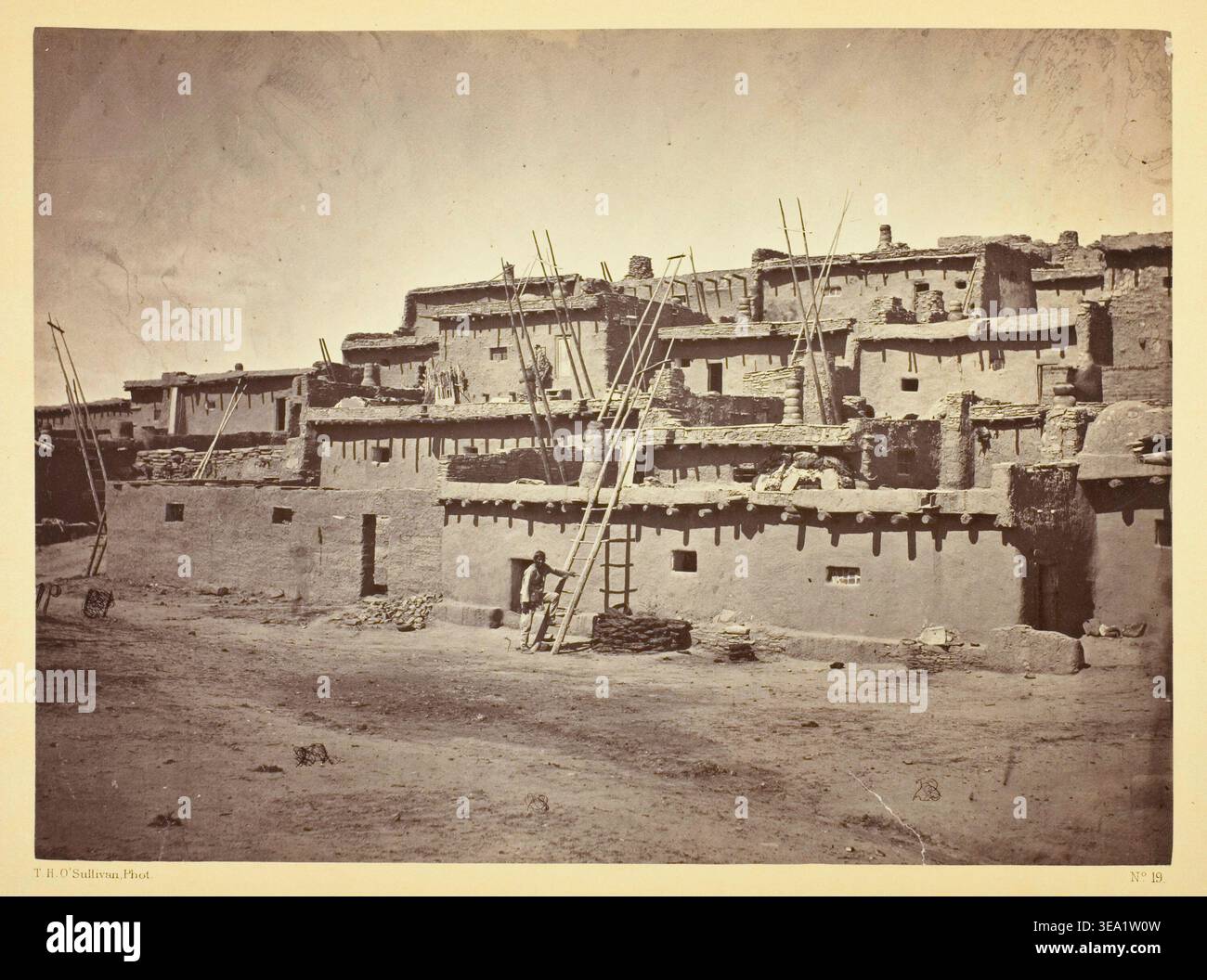 Abschnitt der Südseite von Zuni Pueblo, N.M., von Timothy O'Sullivan, 1873, mit mehrstöckigen lehmziegelwohnungen mit hölzernen Dachstützen und ebenerdigen Zugang Stockfoto