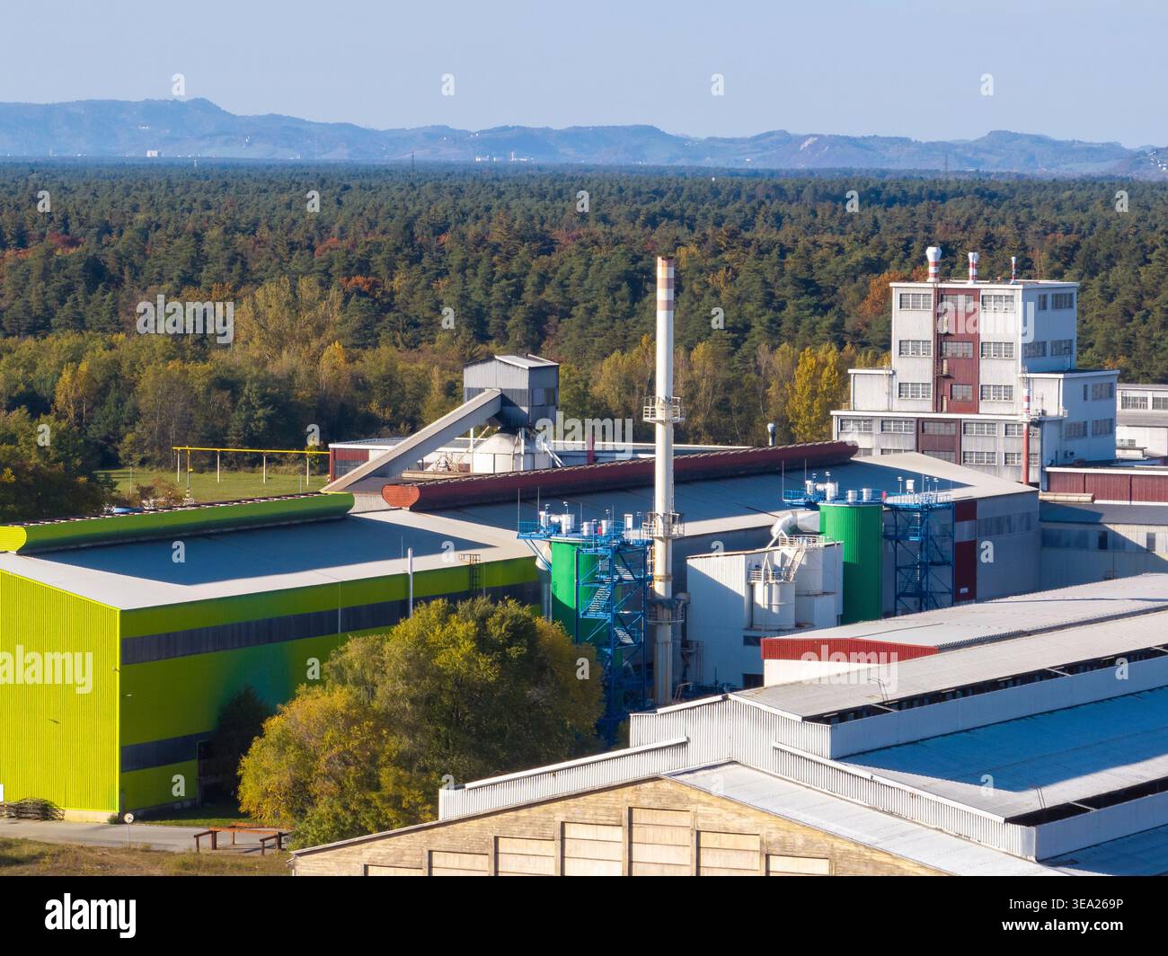 Diese Luftaufnahme zeigt eine große Aluminiumfabrik mit Metallproduktionsanlagen und Infrastruktur in ländlicher Umgebung. Stockfoto