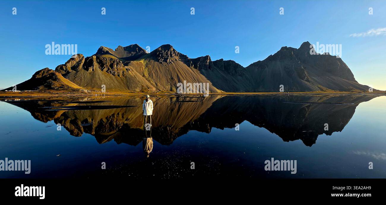 Frau, die den Vestrahorn-Berg beobachtet - Smartphone-aufgenommenes Stockfoto
