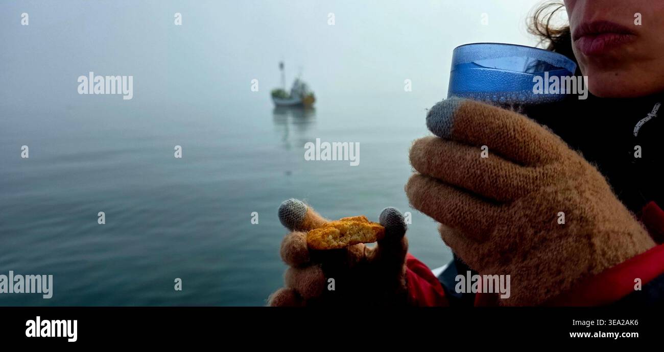 Frau trinkt Kaffee auf einem Boot und beobachtet Wale - Smartphone-aufgenommenes Stockfoto