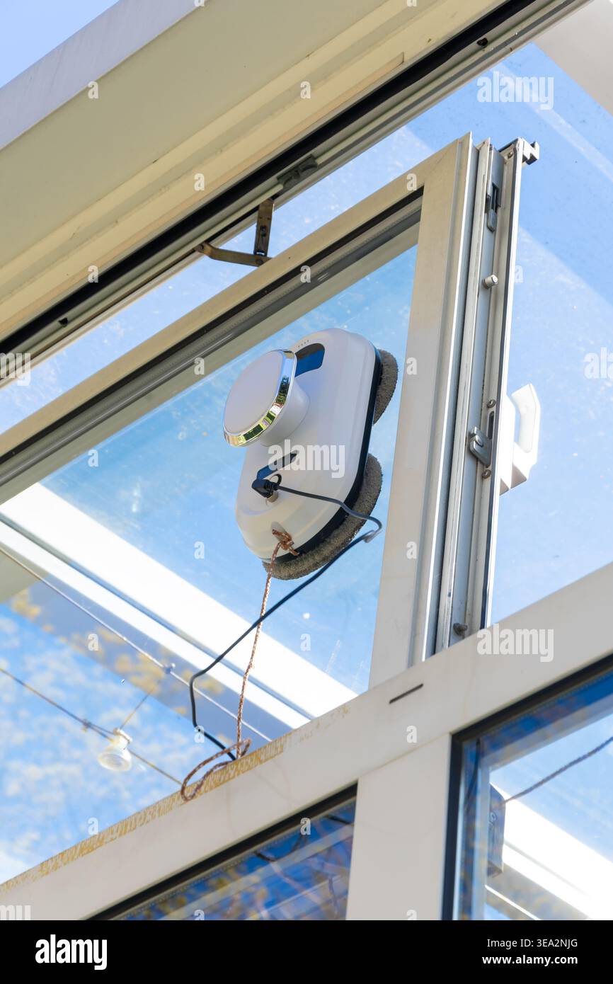 Das automatische Gerät, das am Glas befestigt ist, demonstriert die Staubsaugertechnik. Stockfoto