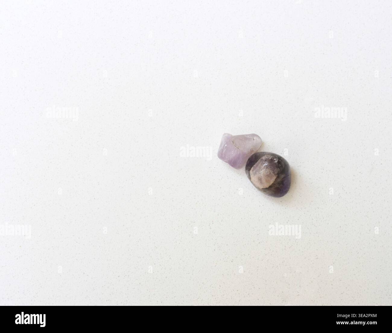 Quarzkristalle und Mineralien auf weißem Tisch minimaler Hintergrund Stockfoto