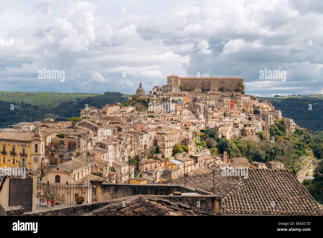 Agrigento antike Ruinen bei Sonnenuntergang mit Stadtlichtern im Hintergrund Stockfoto