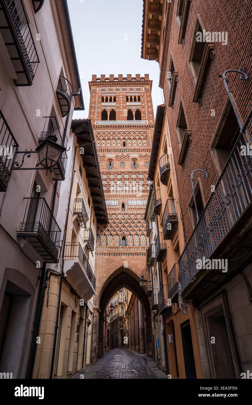 Eine perspektivische Sicht auf den San Salvador Turm in Teruel, Spanien. Dieser majestätische Glockenturm aus dem 14. Jahrhundert im aragonesischen Mudéjar-Stil ragt über einem schmalen Turm Stockfoto