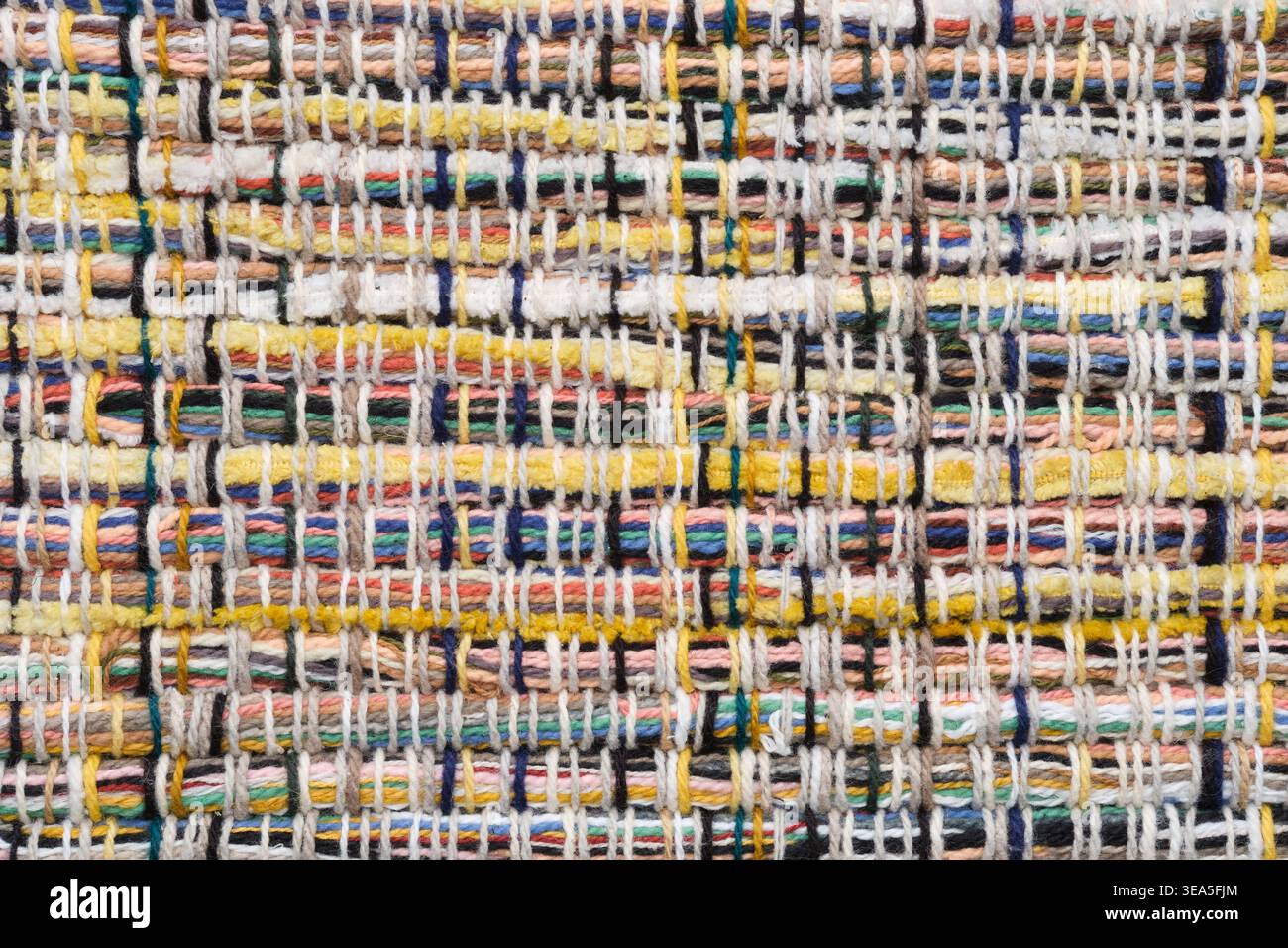 Blick von oben auf handgefertigte, gewebte Teppiche aus dickem Garn auf Holzoberfläche. Rustikaler Textil-Hintergrund mit Kopierraum. Stockfoto