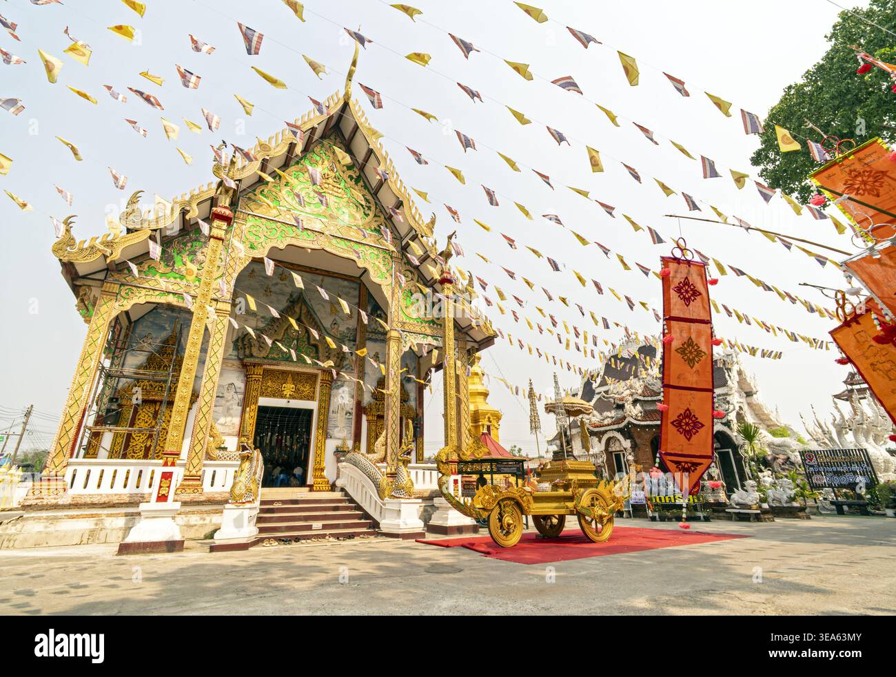 Dok kham Tai, Phayao, Thailand - 20. April 2026: Phra Chao Than Chai mit raffinierten goldenen Dachfinialen, grünen und goldenen Außendetails Stockfoto