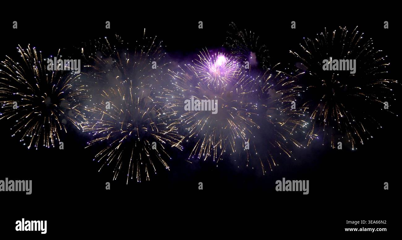 Ein Feuerwerk erleuchtet den Nachthimmel während einer Feier in einer Stadt und erzeugt bunte Muster in der Luft Stockfoto