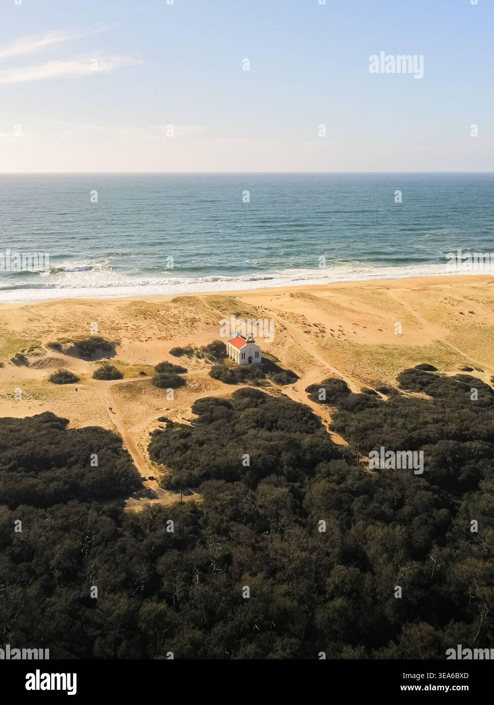 Blick aus der Vogelperspektive auf die Chapelle Sainte-Therese mit ihrem roten Dach, eingebettet in die Sanddünen entlang der Atlantikküste in Labenne, Nouvelle-Aquitaine, Frankreich. Stockfoto