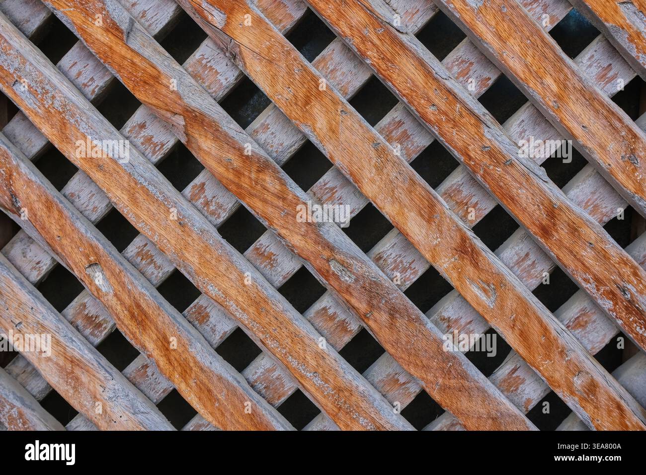 Traditionelle arabische Holzgitterstruktur mit verwitterter Oberfläche und geometrischem Muster. Stockfoto